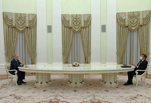 Presidentes da Rússia e da França sentado a mesa durante encontro desta 2ª feira (7.fev) (Reprodução/AP News)