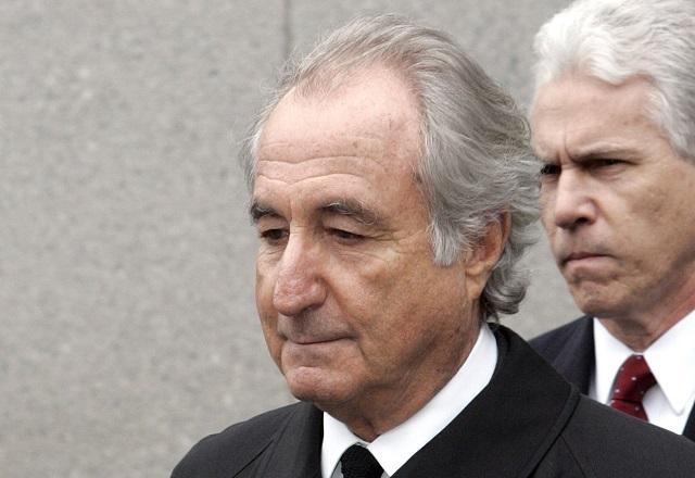 À frente de um outro homem, Bernie Madoff olha para baixo (David Karp/AP News)