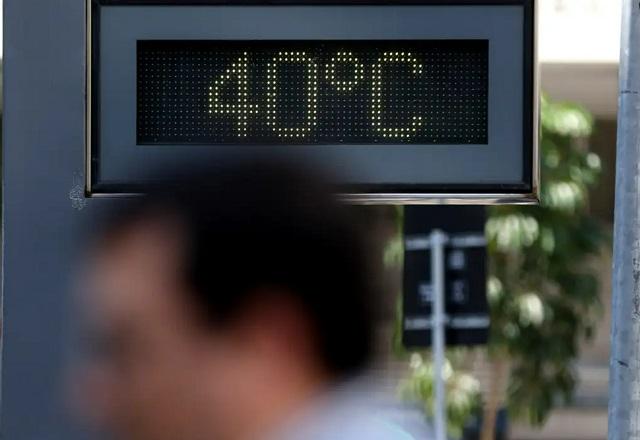 Pessoa passa em frente a termômetro de rua marcando 40ºC (Tânia Rêgo/Agência Brasil)