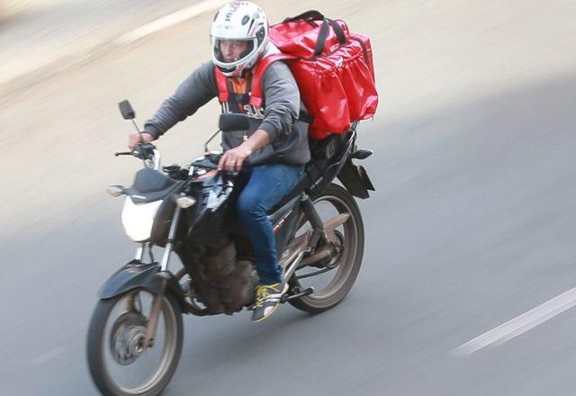 Entregador de aplicativo conduz moto com mochila nas costas (Marcello Casal Jr./Agência Brasil)