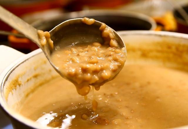Com concha, pessoa despeja feijão em panela na qual  o alimento é preparado (Marcelo Camargo/Agência Brasil)