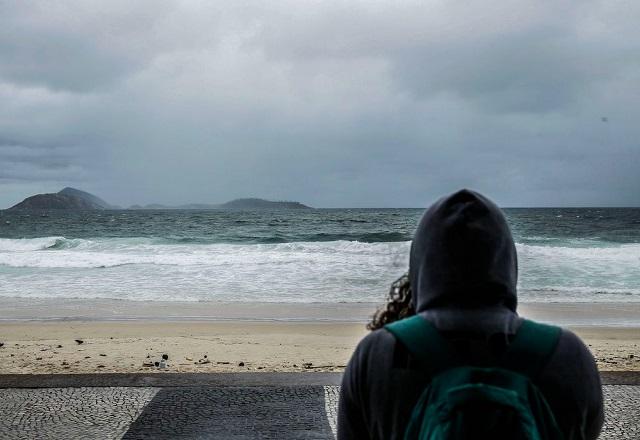 Pessoa com blusa observa o mar no Rio de Janeiro (Tânia Rêgo/Agência Brasil)