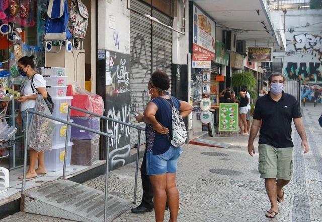 Homem caminha em frente a estabelecimentos (Fernando Frazão/Agência Brasil)