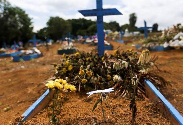 Flores são deixadas à frente de cruz em túmulo (Marcelo Camargo/Agência Brasil)