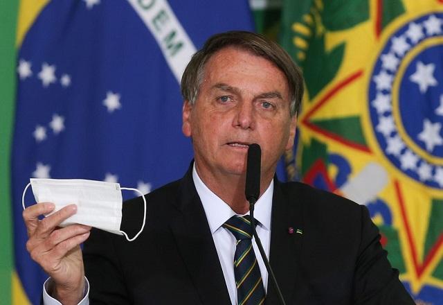 Bolsonaro segura máscara enquanto fala ao microfone (Fabio Rodrigues Pozzebom/Agência Brasil)