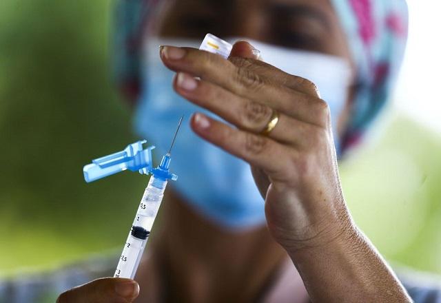 Profissional da saúde insere agulha de seringa em frasco contendo dose de vacina (Marcelo Camargo/Agência Brasil)