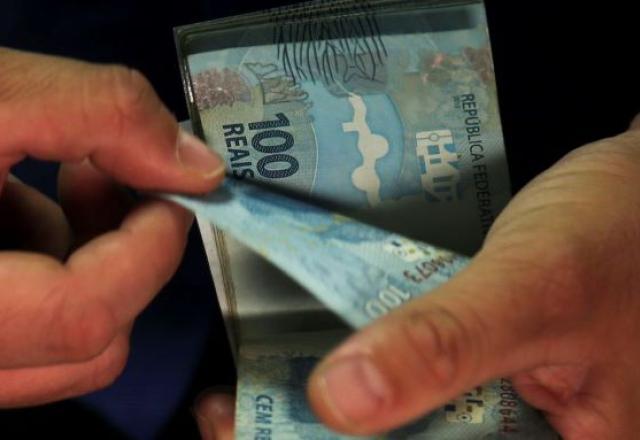 Pessoa manuseia notas de R$ 100,00 (José Cruz/Agência Brasil)