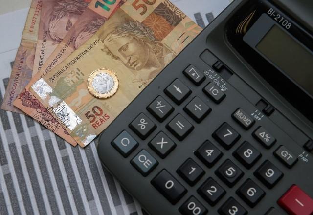 Dinheiro ao lado de calculadora (Marcello Casal Jr/Agência Brasil)