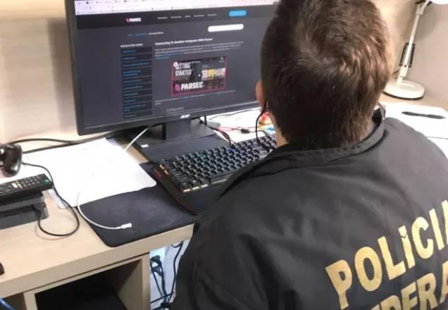Agente da PF apurando informações em um computador