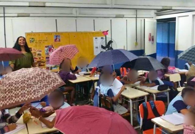 Alunos assistem usam guarda-chuva por causa de goteiras na classe. Em dias de chuva a Escola Professora Maria de Araújo da Silva, em Duque da Caxias, no Rio de Janeiro fica alagada.