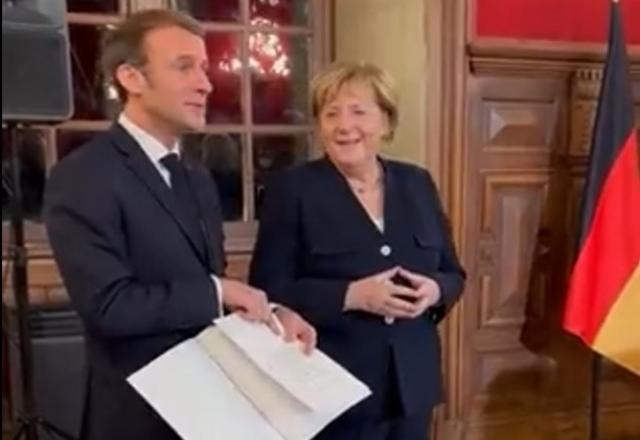 Angela Merkel e Emmanuel Macron na cerimônia de homenagem