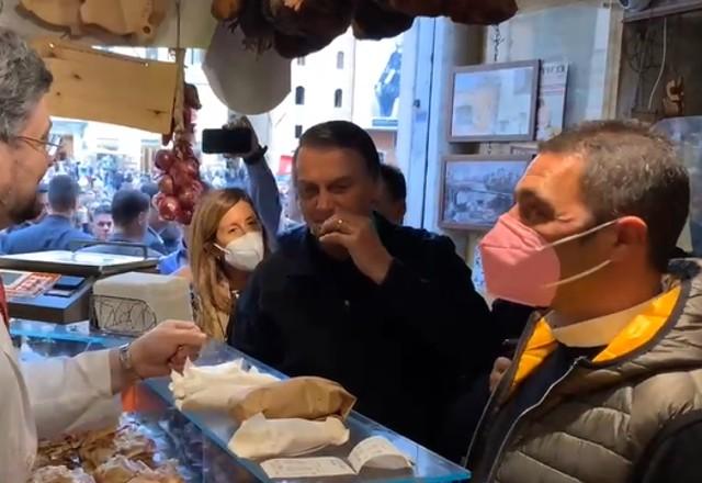 Bolsonaro aparece cercado por apoiadores enquanto está comendo pizza