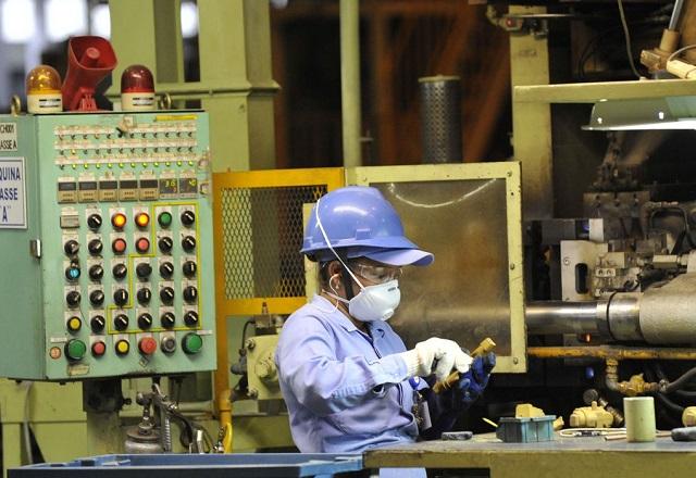 Funcionária manuseia instrumento enquanto trabalha em fábrica (José Paulo Lacerda/CNI)