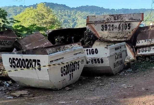 Caçambas de lixo empilhadas em terreno, durante o dia