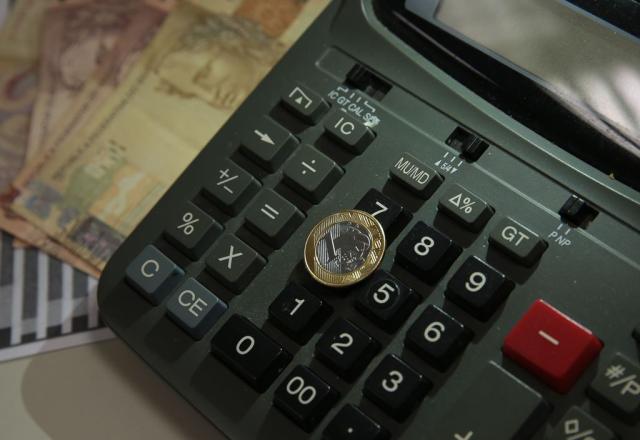 Calculadora, cédulas, moedas, dinheiro