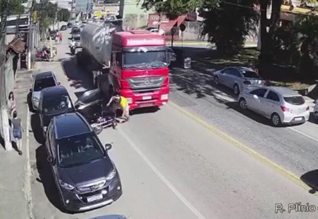 Caminhão vermelho e homem de camisa amarela saindo de baixo
