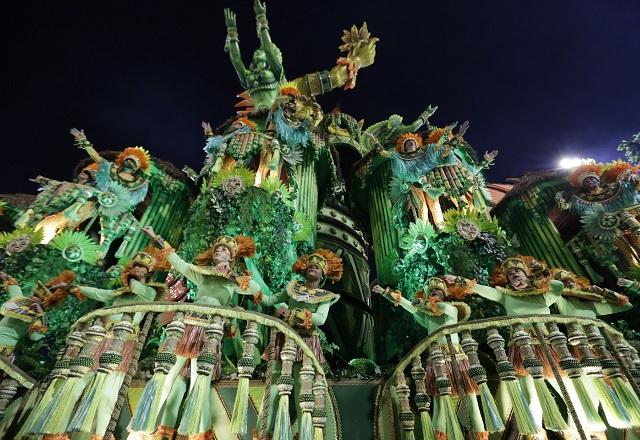 Carro alegórico de escola de samba, visto debaixo para cima, com componentes distribuídos na alegoria em tom verde