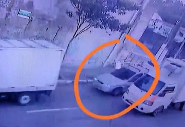 Carro branco ao lado de caminhão, no trânsito