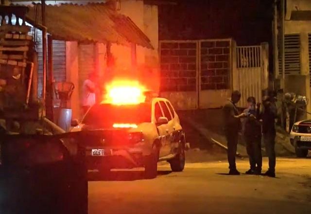 Carro de polícia com sirene ligada em rua durante a noite