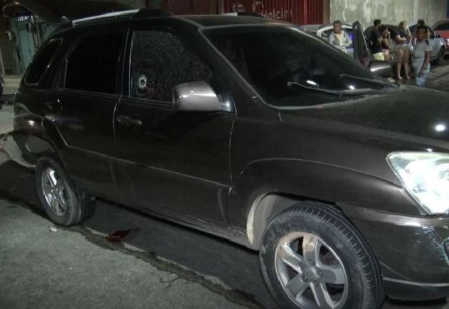 Carro preto com marca de tiro no vidro lateral