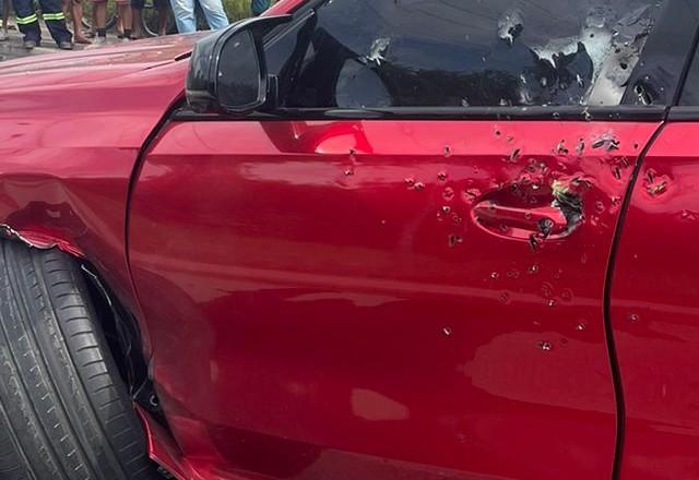 Carro vermelho com marcas de tiros
