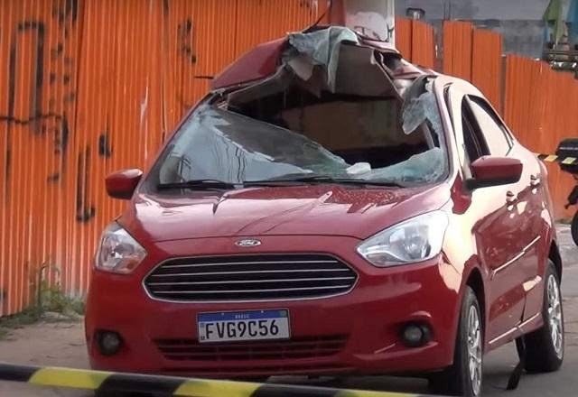 Carro vermelho com para-brisa estilhaçado após ser atingido por cilindro de gás veicular em rua de Osasco (SP)