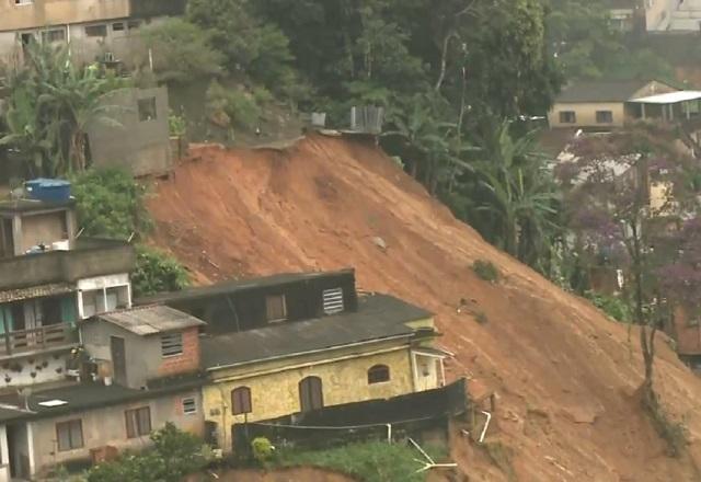 Casas em região montanhosa ao lado de área de deslizamento de terra após chuvas em Petrópolis