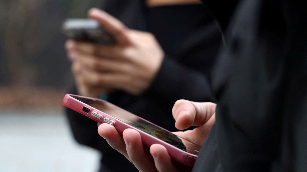 Adolescentes olham para as telas de seus celulares em Paris | Manuel Ausloos/Reuters