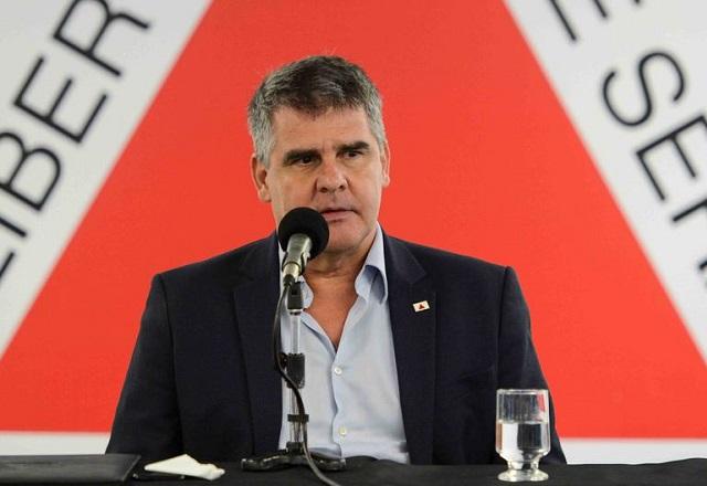 Paulo Brant fala ao microfone, à frente da bandeira de Minas Gerais (Ascom/Cimams)