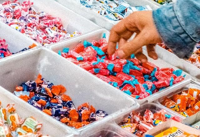 Cliente pegando doce em comércio