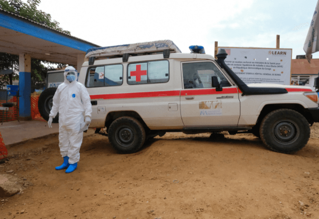 Médico com EPI ao lado de uma ambulância no Centro de Tratamento da Doença pelo Vírus Ebola do Hospital Geral de Referência de Bunia, na República Democrática do Congo | Foto: Gradel Muyisa Mumbere/Reuters - 15.06.2026