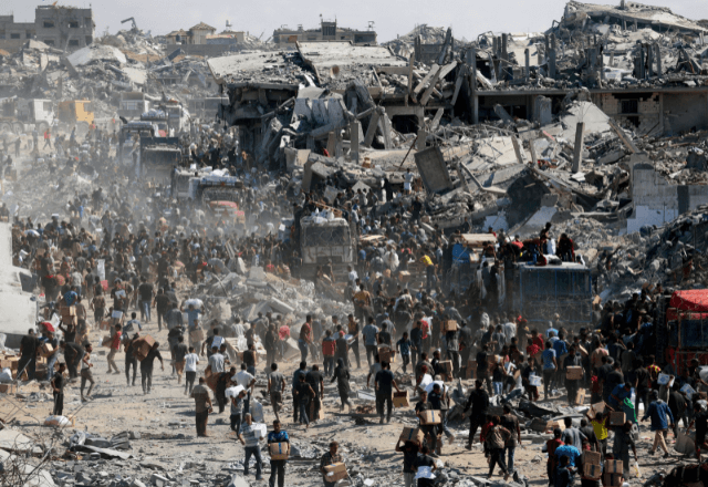 Palestinos buscam suprimentos de ajuda de caminhões que entraram em Gaza | Foto: Ramadan Abed/Reuters - 12.10.2025