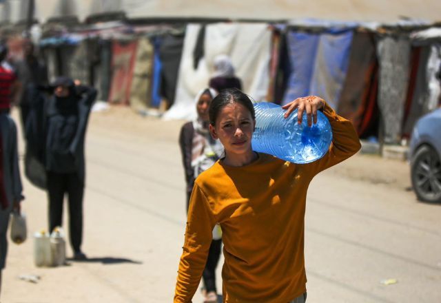 Criança palestina carrega galão de água em área da Faixa de Gaza atingida por bombardeios israelenses |Divulgação/ UNRWA