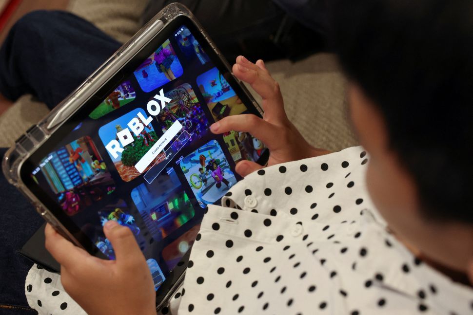 Criança usa iPad para acessar a plataforma Roblox | 12 de março de 2026/Reuters/Ajeng Dinar Ulfiana