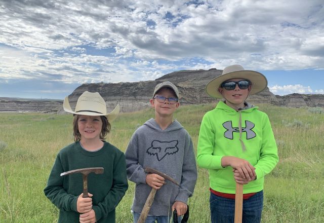 Liam Fisher, Kaisen Madsen e Jessin Fisher em frente à colina onde descobriram o esqueleto T.rex | Tyler Lyson/Museu de Natureza e Ciência de Denver