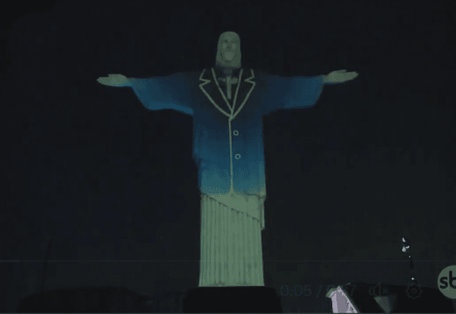 A estátua foi iluminada por uma projeção especial que vestiu a imagem com um terno e um microfone | SBT/Reprodução