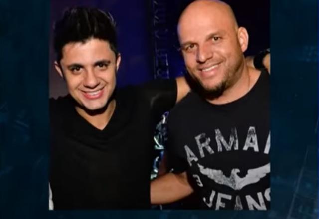 Dois homens se abraçando e sorrindo para foto