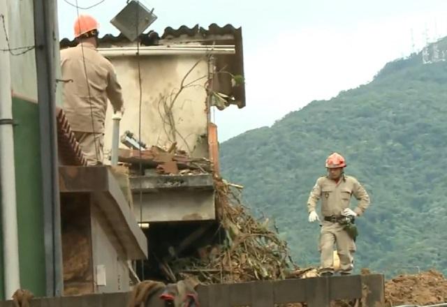 Dois trabalhadores de equipes de resgate sob escombros de casas em Petrópolis (RJ)