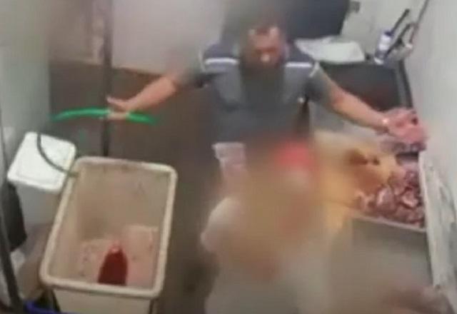Dono de açougue segurando mangueira usada para agredir funcionário em Porto Velho (RO)