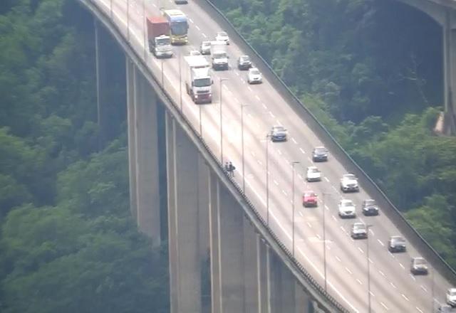 Imagem de câmera de monitoramento mostra dupla se preparando para atravessar rodovia e saltar de viaduto (Reprodução/Ecovias)