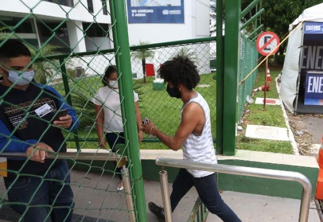 Estudante entrando em colégio para exame do Enem