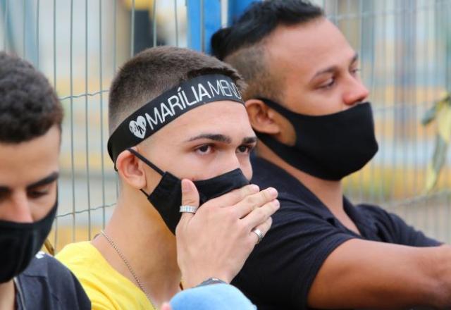 Fã com faixa de Marília Mendonça chora