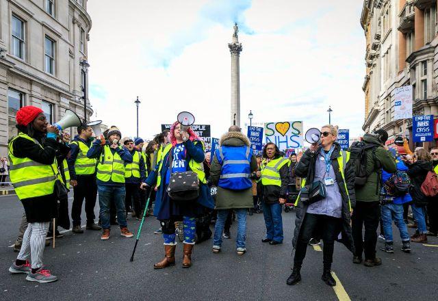 Grupo alega que vem sofrendo piora nas condições de trabalho e cortes salariais, que, desde 2008, já somam 26% em termos reais | Reprodução/Facebook NHS Workers Say NO