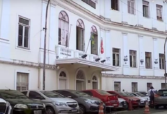 Fachada da faculdade com carros estacionados em frente
