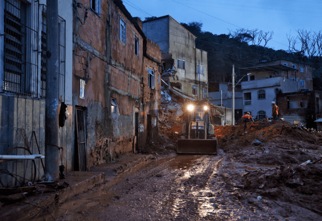 Bombeiros e voluntários fazem buscas por pessoas em escombros de casas soterradas por lama após fortes chuvas em Juiz de Fora (MG) | Foto: Tânia Rêgo/Agência Brasil - 24.02.2026