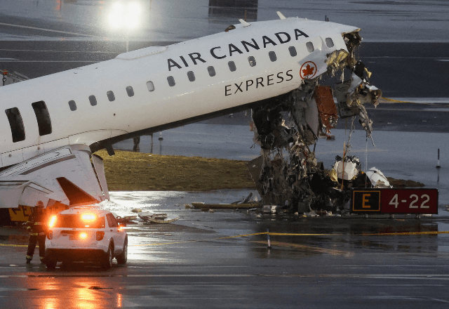 Destroços pendurados em avião da Air Canada Express após colisão com caminhão de bombeiros na pista do Aeroporto LaGuardia, em NY | Foto: Shannon Stapleton/Reuters - 23.03.2026
