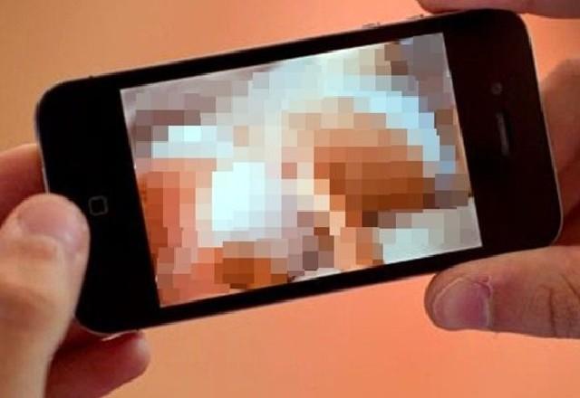 Foto de duas mãos segurando um celular com imagem borrada