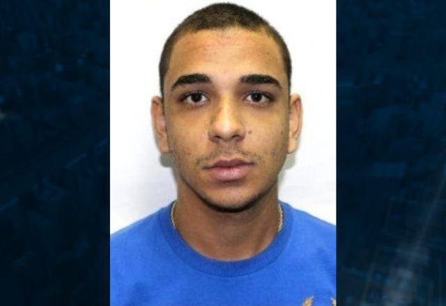 Foto de homem moreno no formato 3x4, de camiseta azul e fundo branco