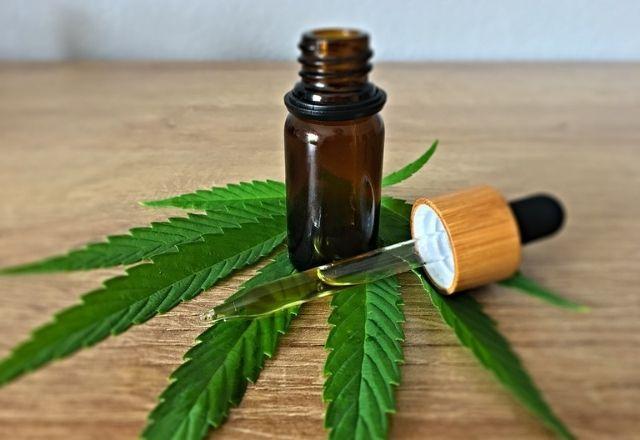 Frasco com substância se encontra sobre folha de cannabis em superfície (Pixabay)