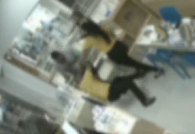 Funcionários de ótica, de camiseta amarela e calça preta, tentam conter homem de camiseta cinza que agride um dos trabalhadores